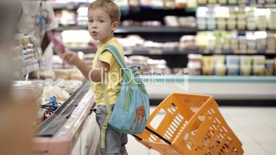 Boy putting products into shopping cart