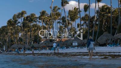 People walking along the beach on tropical resort