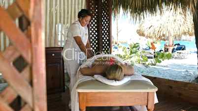 Woman getting professional massage on tropical resort
