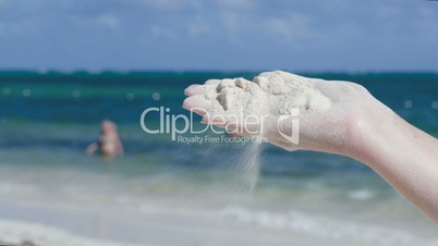 Sand vanishing  from female hand on the beach