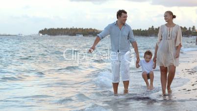 Parents and their child walking along the beach