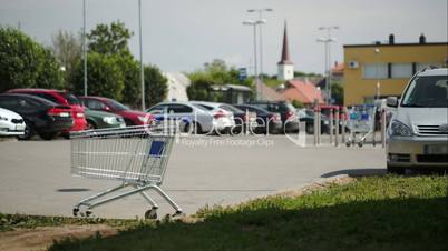 Timelapse of traffic on parking zone with empty shopping cart