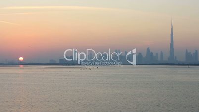 view of Dubai skyscraper and Burj Khalifa at sunset