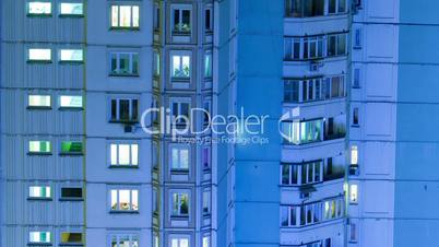 Timelapse of multistorey building with twilnkling lights in late evening