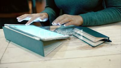 Woman working with pad and taking notes in notebook