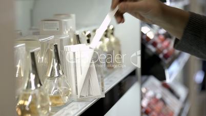 Woman in the shop choosing perfume with paper tester