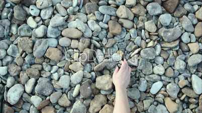 Male hand taking and throwing pebble stones