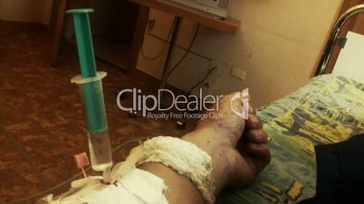 Hand of sick person with syringe and drip