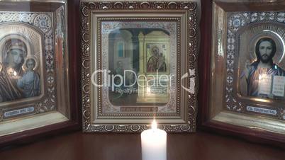 candle burns near Orthodox icons