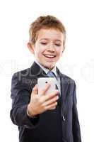 Smiling child boy in business suit holding mobile phone or smart