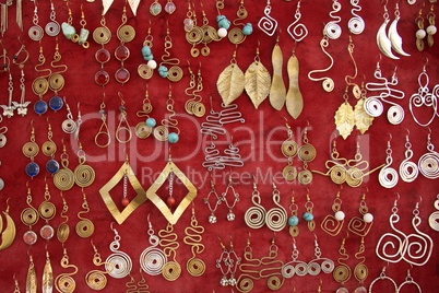 Gold and silver earrings on red velvet