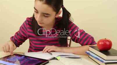 Schoolgirl doing her homework with digital tablet