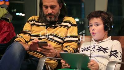 Father and son waiting at the airport