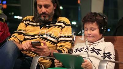 Father and son waiting at the airport