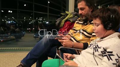 Father and son waiting at the airport