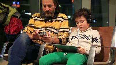 Father and son waiting at the airport