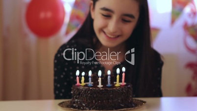 Young girl blowing candles on birthday cake