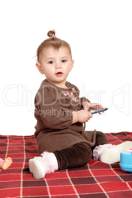 Baby girl sitting on blanket.
