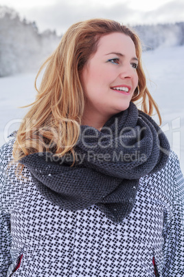 Portrait einer blonden molligen Frau in Winterjacke und dickem Schal.