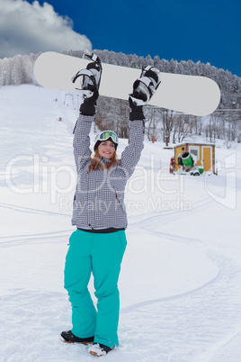 Junge mollige Frau in Siegerhaltung , hebt Ihr Snowboard in die Luft.