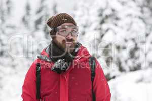 Young man with snow glasses smiles into the camera