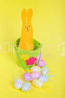 Easter rabbit in bucket on yellow