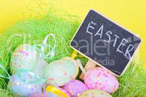 Ester eggs in nest with copy-space chalkboard