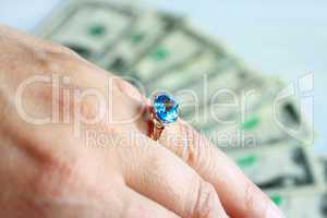 Hand with topaz on the finger and dollars
