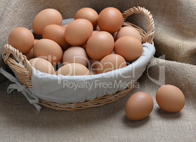 chicken eggs in a basket on sackcloth