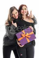 2 Mädchen mit Geschenk zeigen Daumen hoch