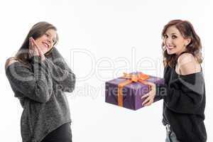 Mädchen überreicht Freundin ein Geschenk