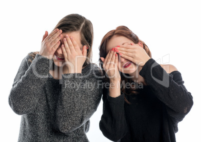 Zwei Mädchen halten sich die Augen zu