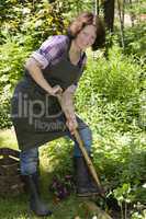 Frau mit Spaten im Garten, Woman with spade in a garden