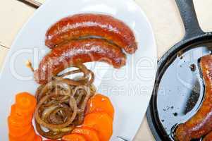 beef sausages cooked on iron skillet
