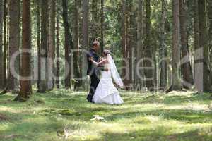 Bride and groom dancing in the forest