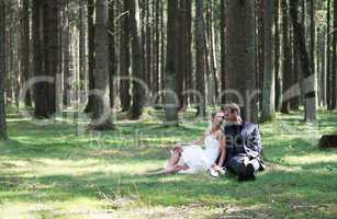 Bride and groom sitting in the woods