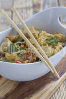 Bowl with asian noodles chicken and chopsticks