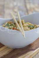 Bowl with asian noodles chicken and chopsticks