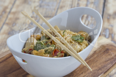 Bowl with asian noodles chicken and chopsticks