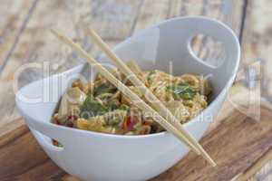 Bowl with asian noodles chicken and chopsticks