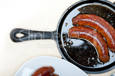 beef sausages cooked on iron skillet