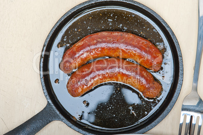 beef sausages cooked on iron skillet