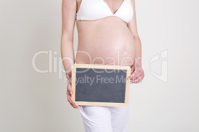 Pregnant woman with an empty blackboard