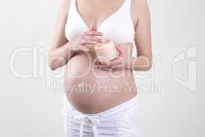Pregnant woman putting creme on her belly