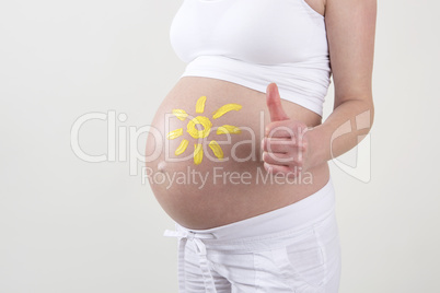 Pregnant woman with yellow sun painted on her belly