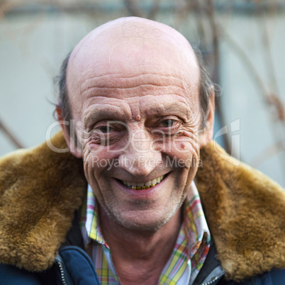 Portrait of a smiling elderly man outdoors closeup