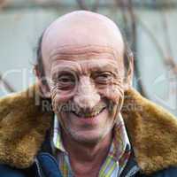 Portrait of a smiling elderly man outdoors closeup