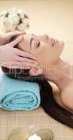 Young woman having a head massage in a spa
