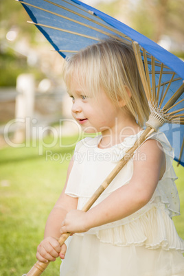 Cute Baby Girl Holding Parasol Outside At Park