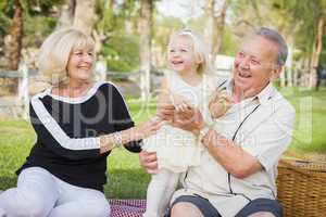 Affectionate Granddaughter and Grandparents Playing At The Park